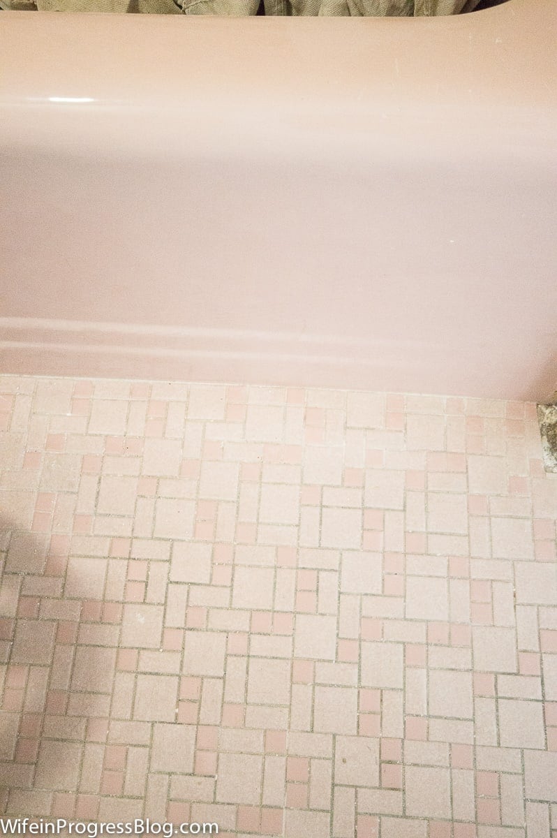 The small, pink and white tiles on the floor near the pink tub