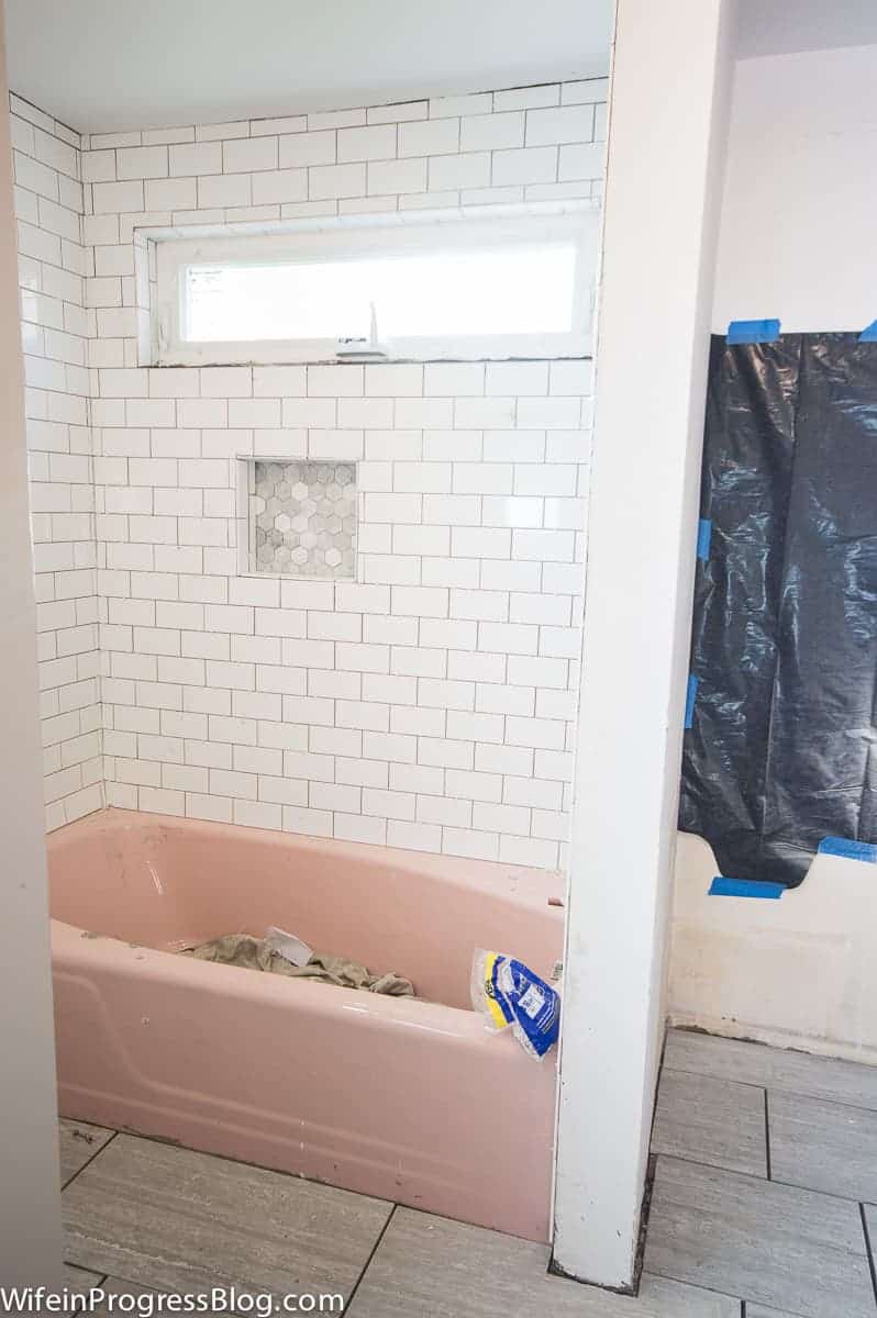 The pink tub on the left, and the recessed area where the sink will be placed on the right