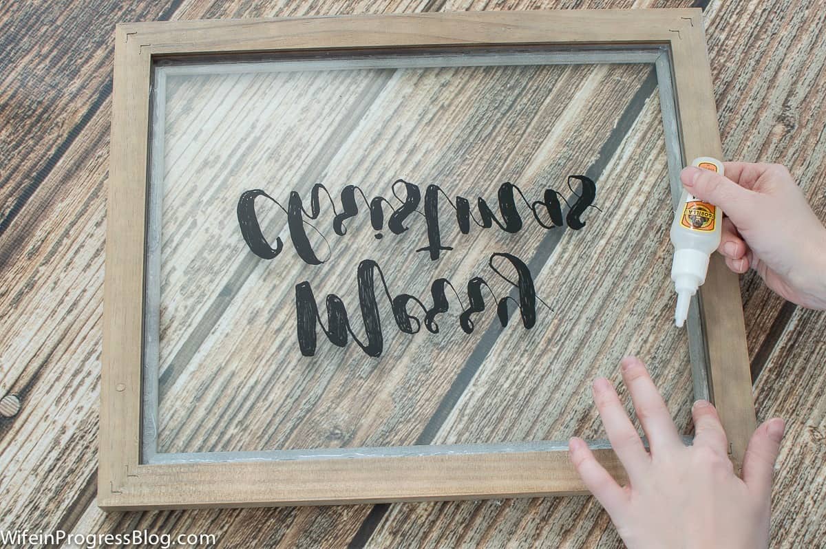 Use a glue pen to secure the glass in your DIY farmhouse style Christmas sign