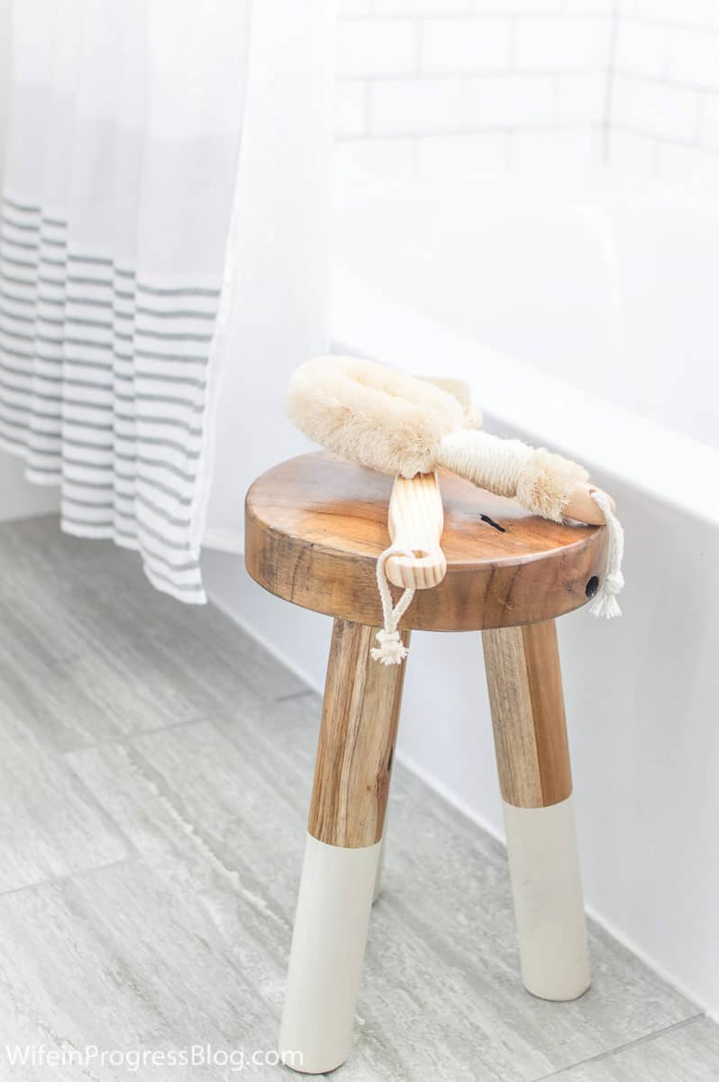 Bath accessories resting on wooden bath stool with painted legs