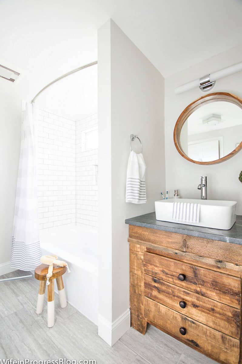 Vanity with farmhouse sink and wood  door that looks like three drawers but swings open