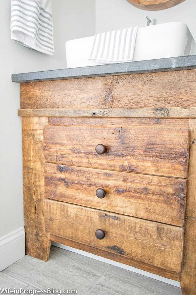 Closer look at wood details of reclaimed wood vanity that add charm to a farmhouse bathroom