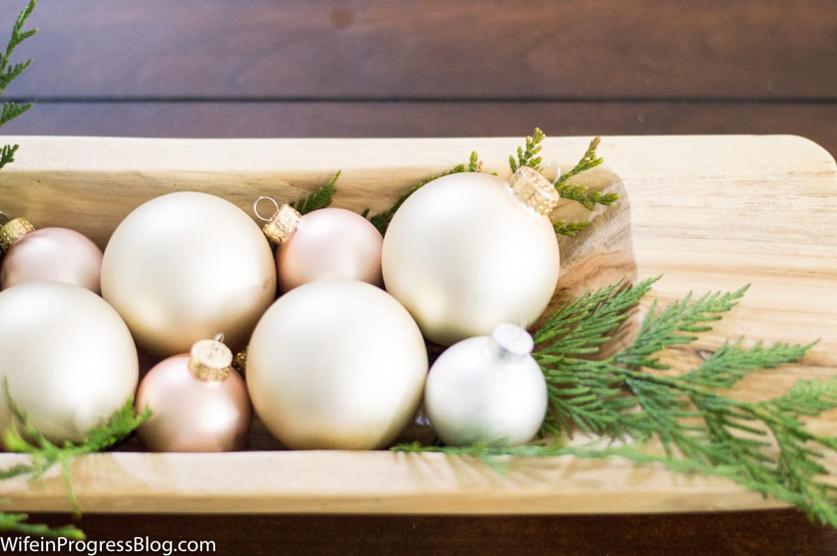 Add some fresh greenery to a dough bowl with ornaments. Farmhouse style Christmas decorating ideas that are easy to copy in your own home!