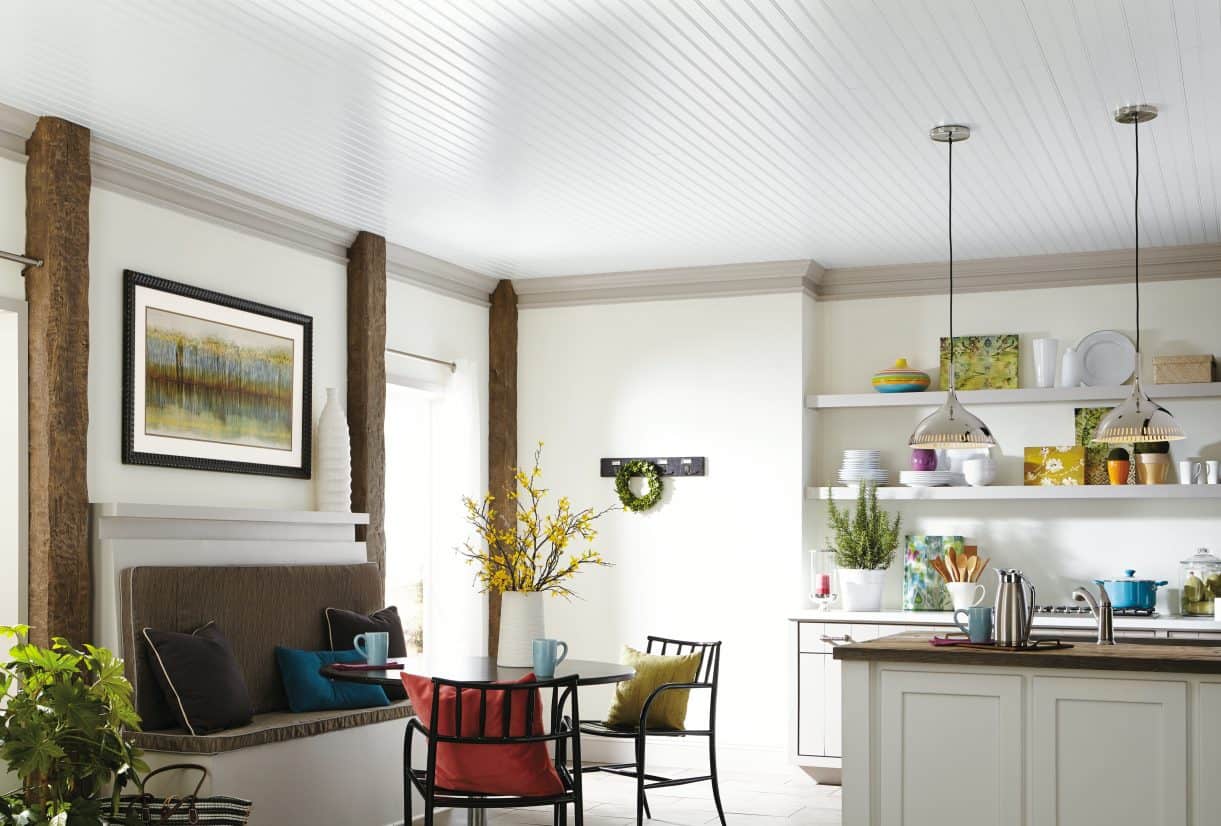 Kitchen and dining nook with many floral arrangements, pendant lights and white beadboard ceiling