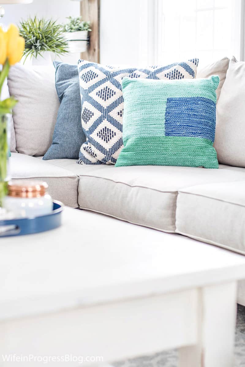 a sofa with blue and green throw pillows for spring