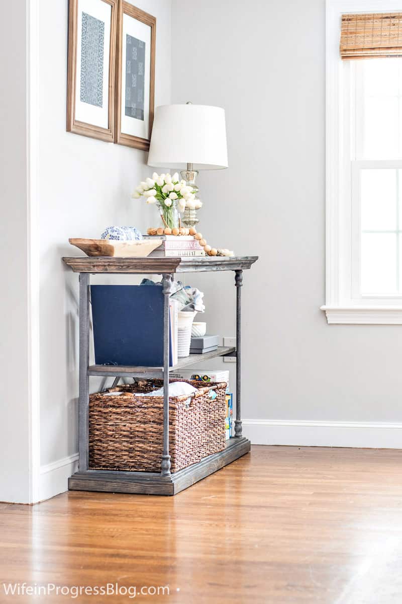Simple way to hide to clutter in a living room. Use baskets in a console table like this