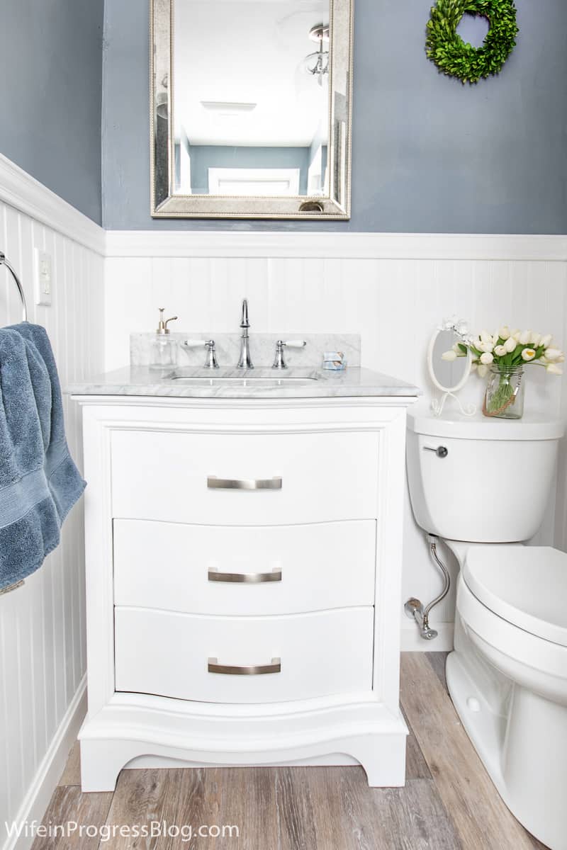 small bathroom with white vanity, white wainscoting and upper walls painted sherwin williams serious gray