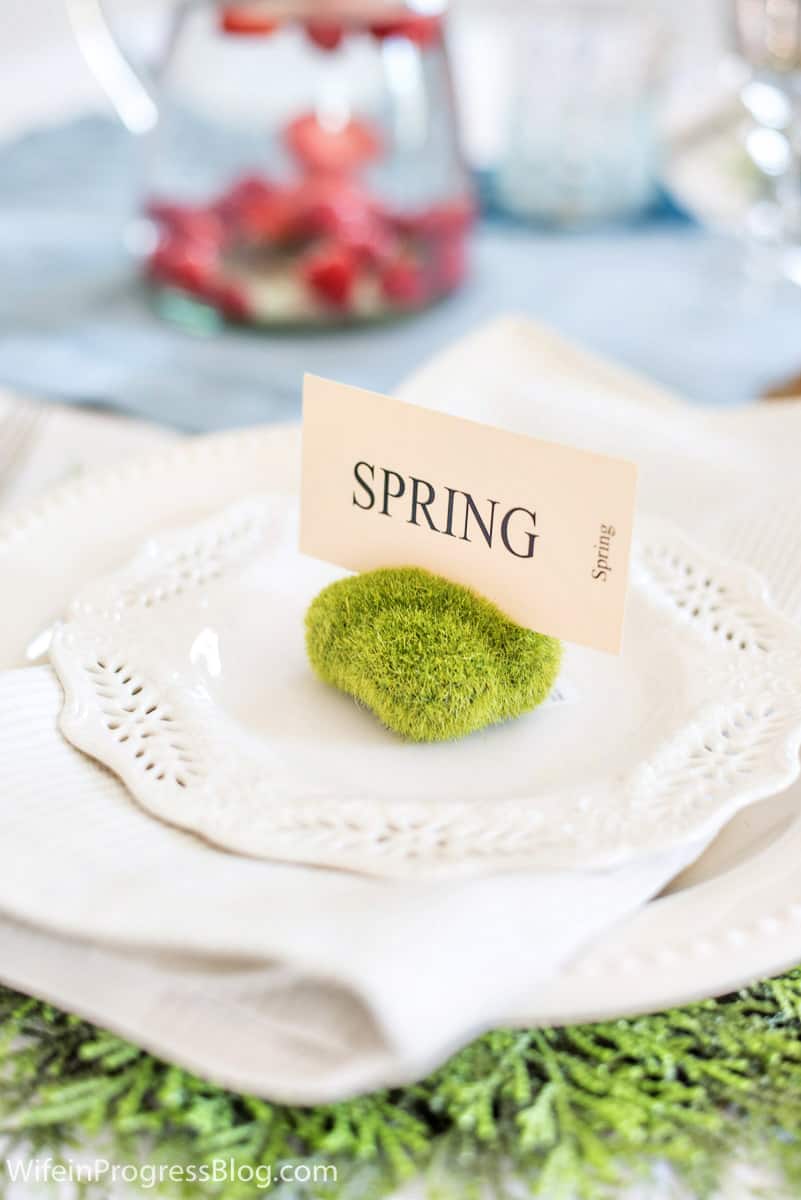 Close-up of a Spring table setting with a mossy rock and place card