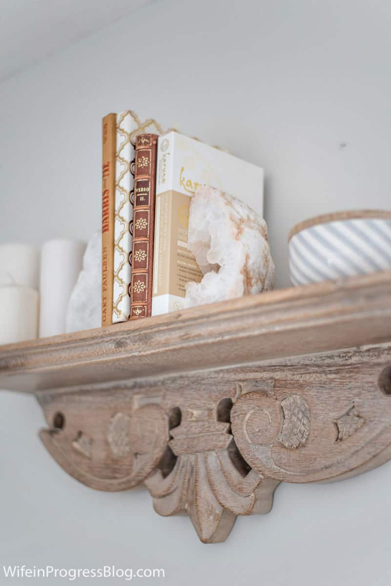 A floating shelf on the wall of this rustic and charming master bedroom makeover