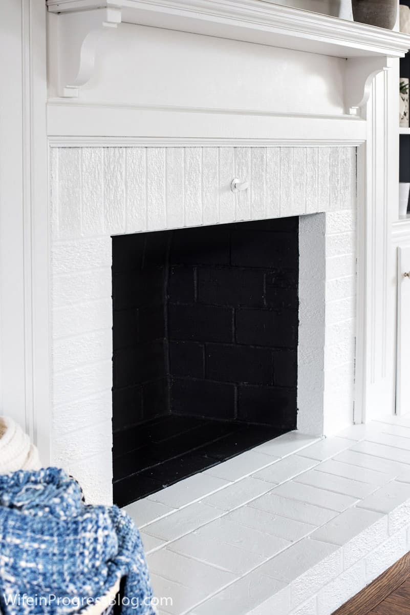 Interior of fireplace painted black set against crisp white fireplace.