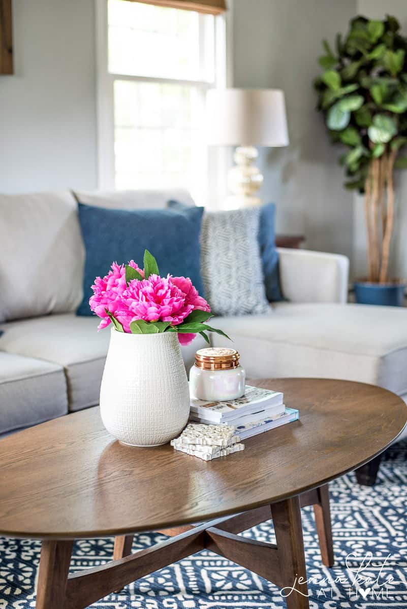 Coastal inspired living room with navy blue, grays walls and pops of bright white.