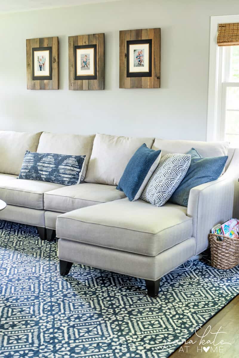 Blue rug under a large beige sectional.