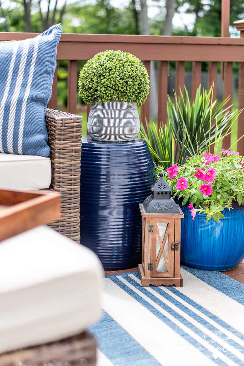 Outdoor patio area with fresh flowers, decor, and blue and white rug