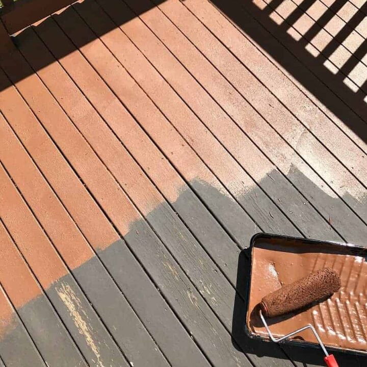 Old brown deck surface in the process of being coated with a resurfacing product using a paint roller