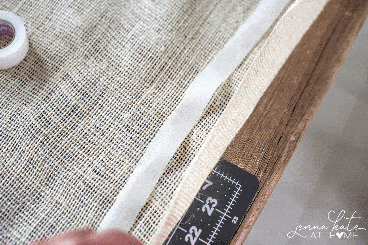 The hem of the long side of the burlap runner being folded over onto the inserted fusing tape.