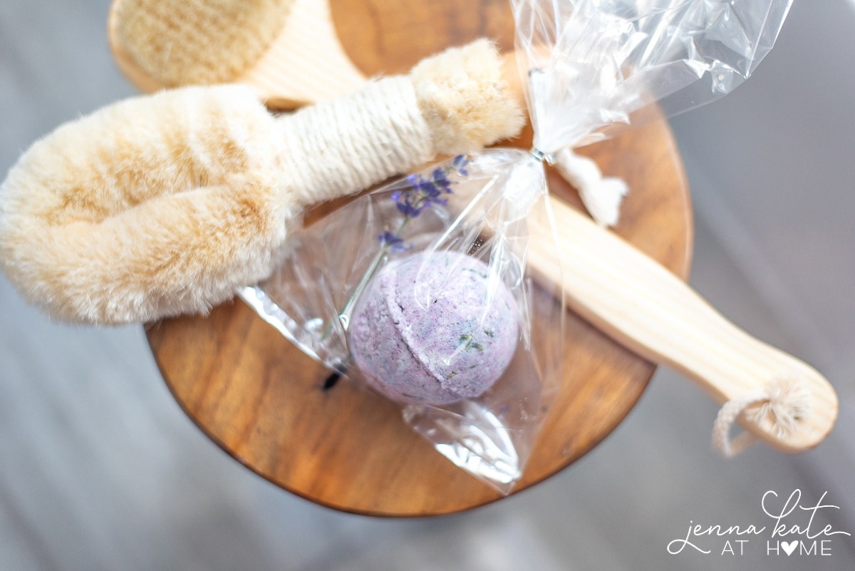 Bath bomb and various bath brushes on wooden stool 