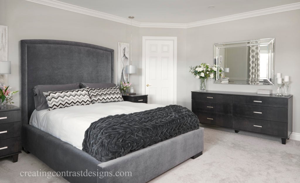 Bedroom walls painted revere pewter with black furniture and dark gray bed.