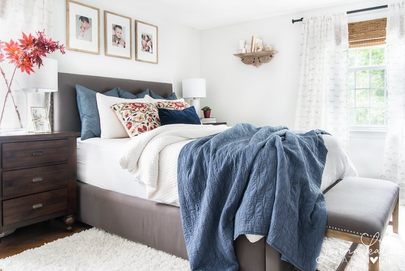 bedroom with Benjamin Moore Paper White walls and a dark gray bed with blue and white bedding.