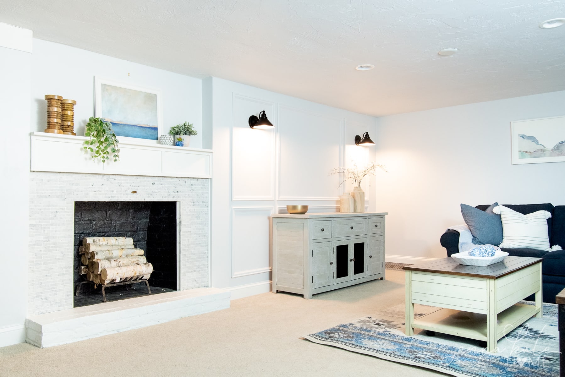 basement living room with navy couch and a fireplace