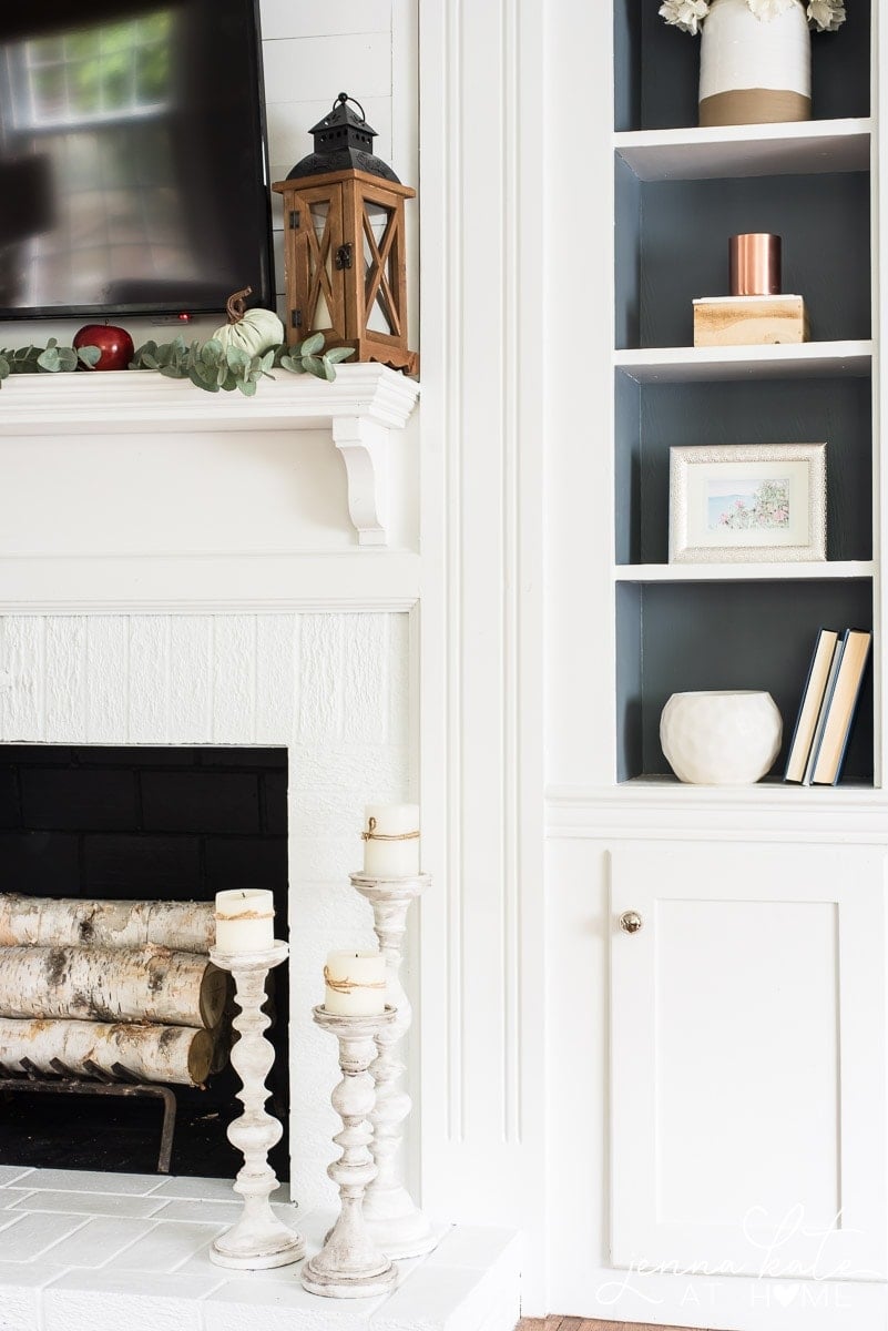 I added pops of green, red, and dark wood to my all-white fireplace mantel for some affordable fall mantel decor