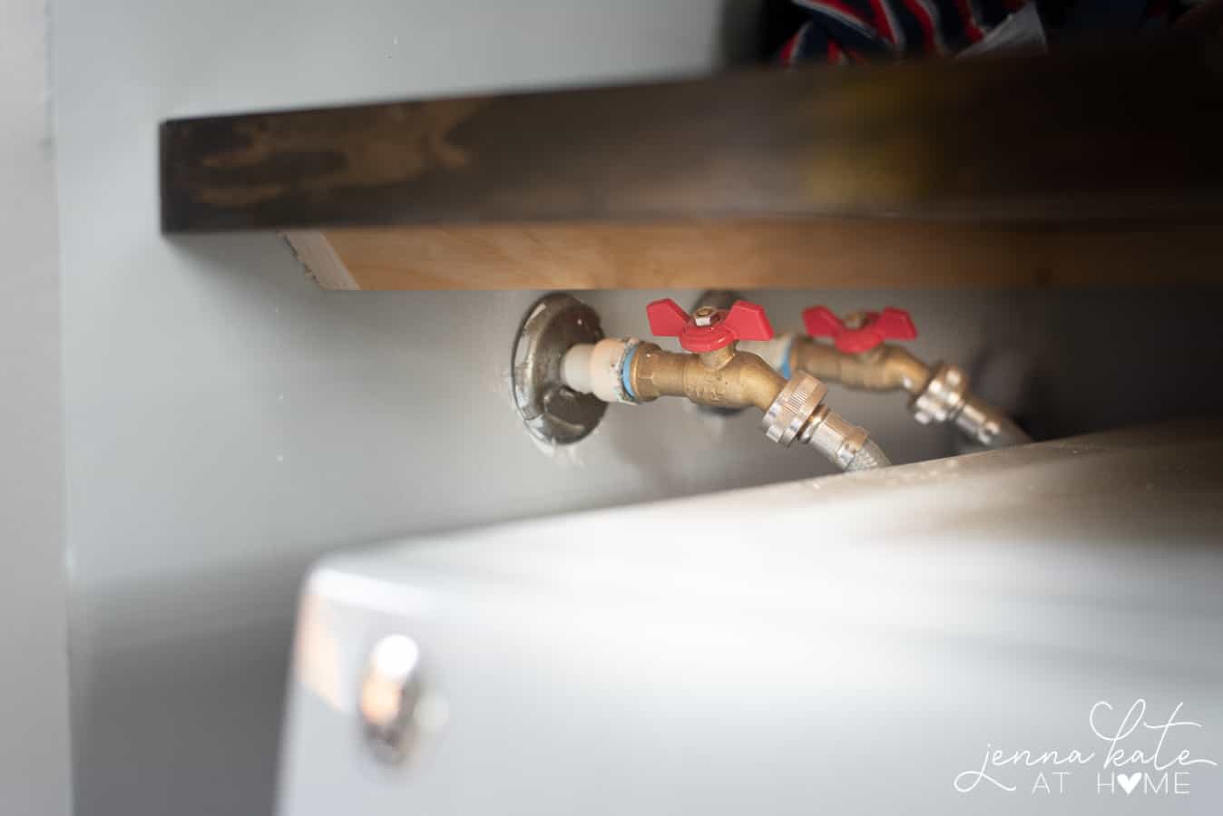 The new countertop installed over the water connections for the washer, giving adequate access to pipes. 