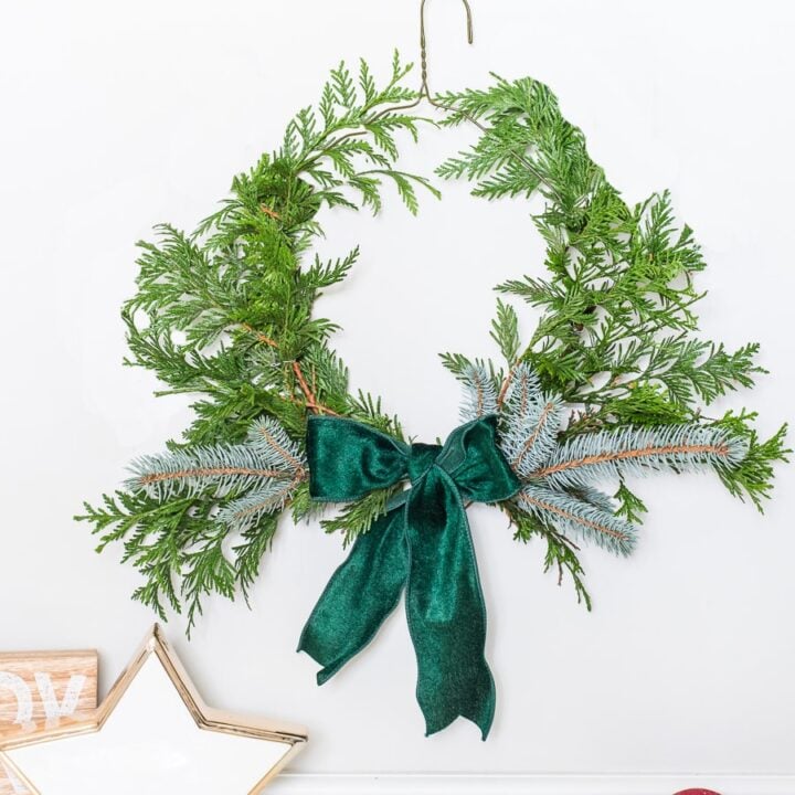 A DIY Christmas wreath using evergreens on a wire clothes hanger