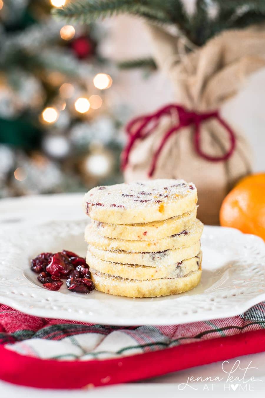 Christmas shortbread cookies stacked high with dried cranberries on a plate