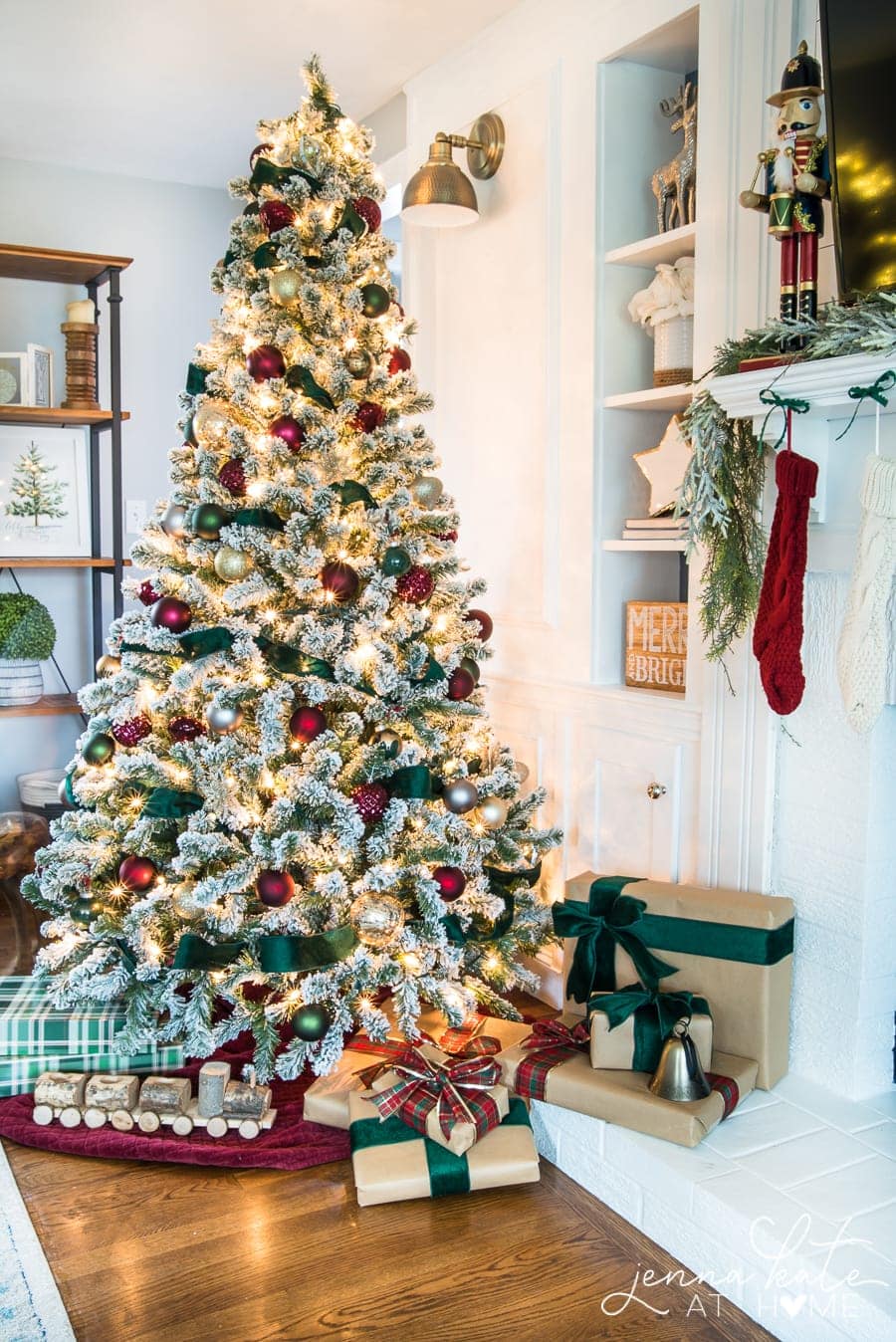 The Christmas tree with burgundy ornaments and green ribbon and the presents below, wrapped in kraft paper and burgundy/green ribbon