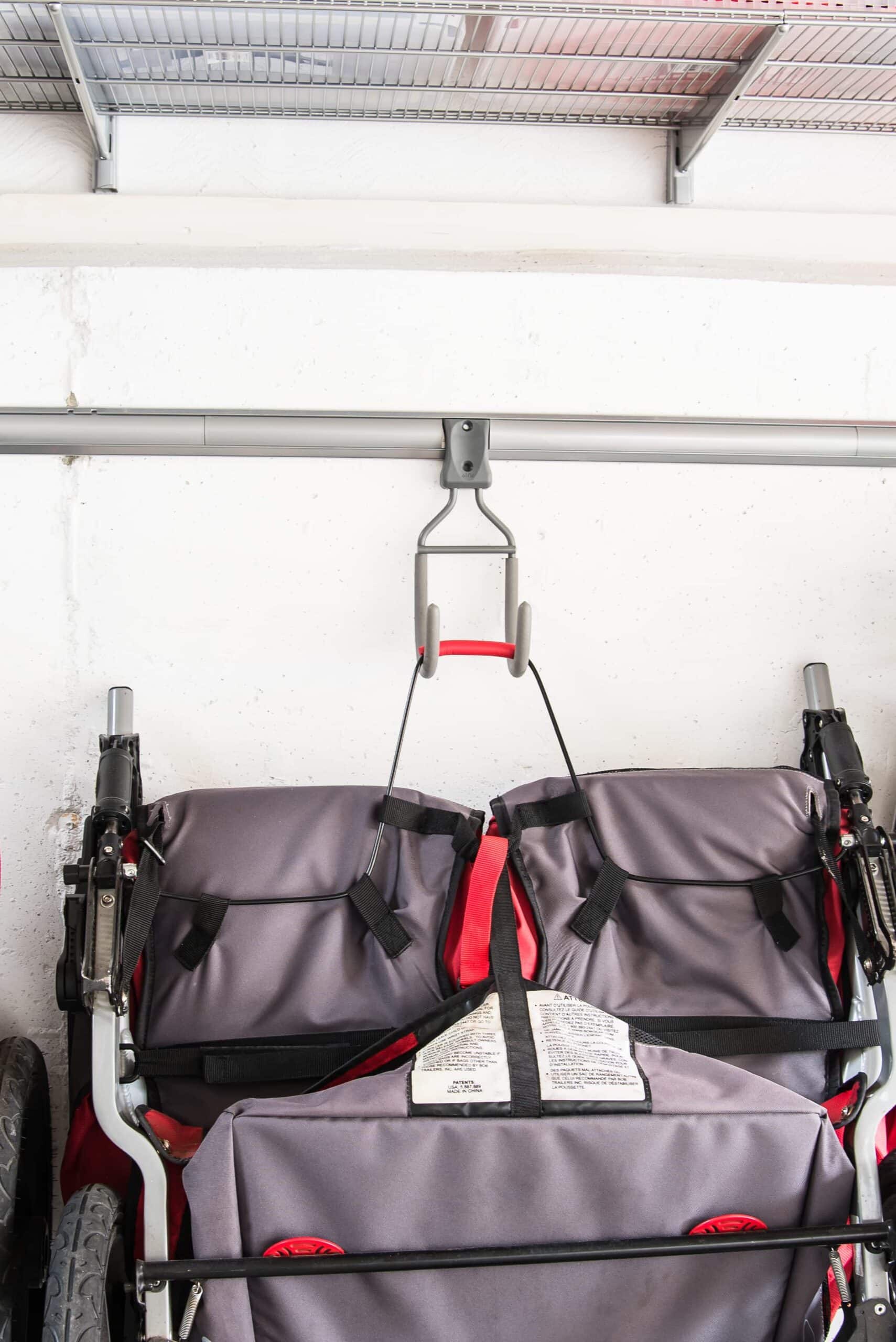 A stroller hanging on a wall hook.