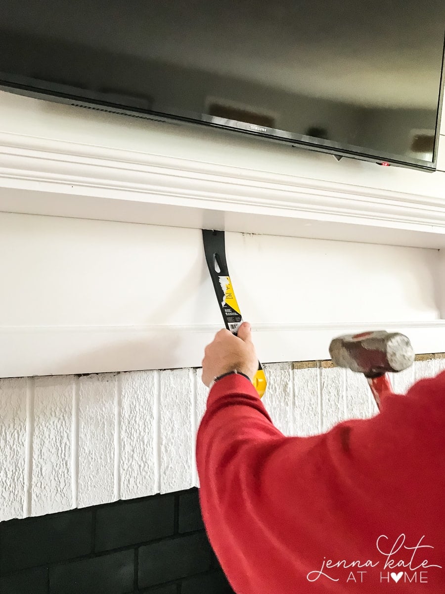 Removing the old mantel with a hammer and trowel