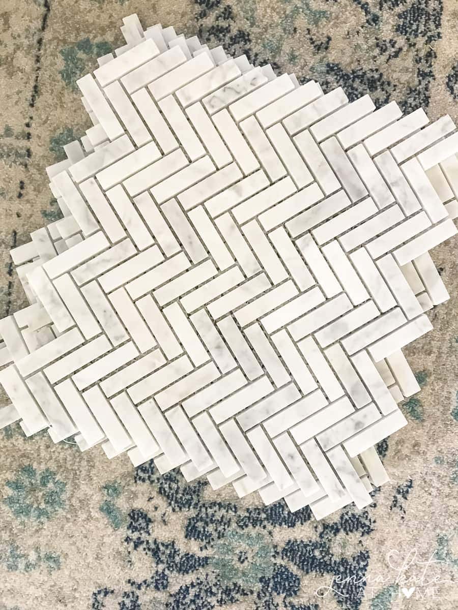 A group of narrow grey tiles, placed in a diagonal pattern, resting on a blue and white rug