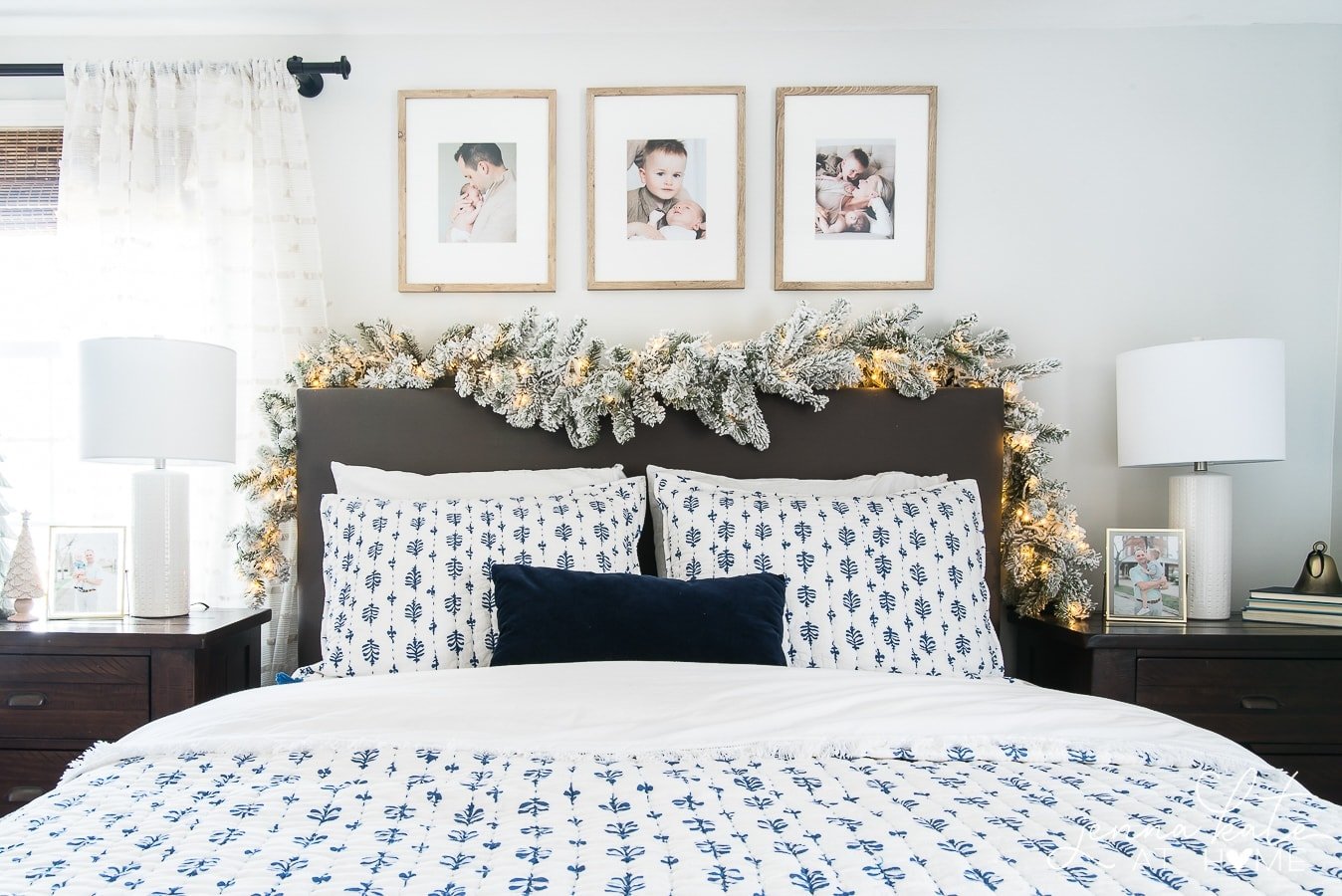 headboard with flocked garland and Christmas lights draped over it