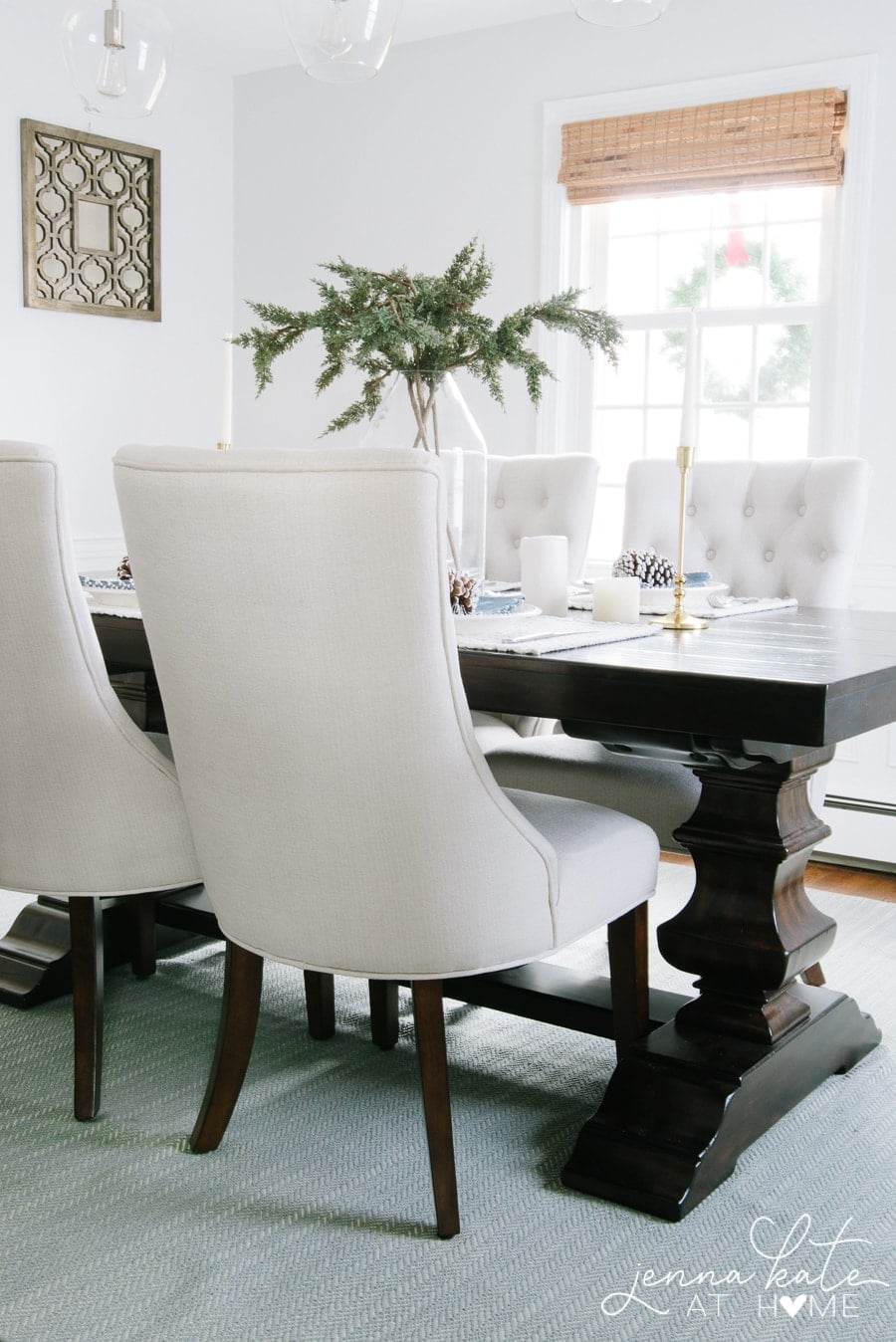 Light gray dining room with a dark wood table with a winter themed table setting
