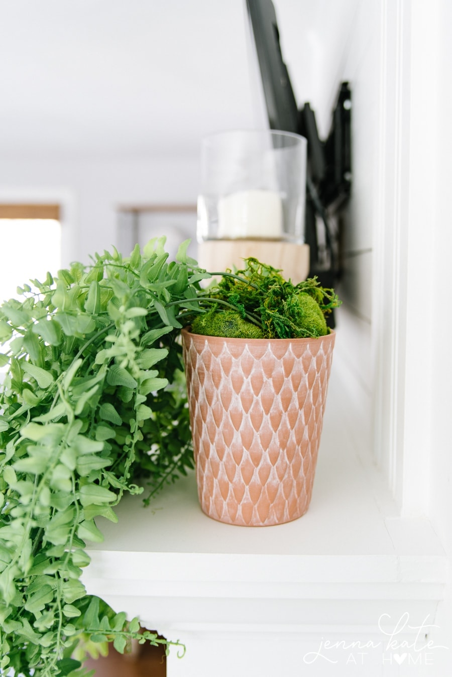 Faux moss and rocks help conceal the stems of your potted faux trailing plant