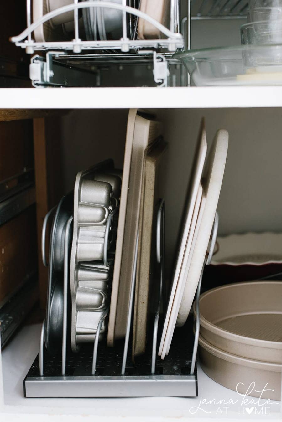 Freestanding baking sheet organizers filled with muffin tins, cookie sheets, and more.