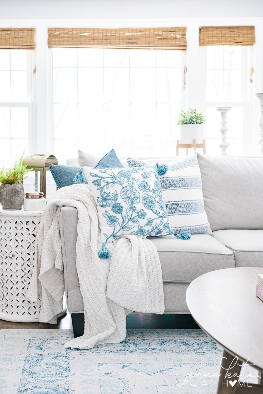 Light and airy living room with grey couch and blue and white decor. 