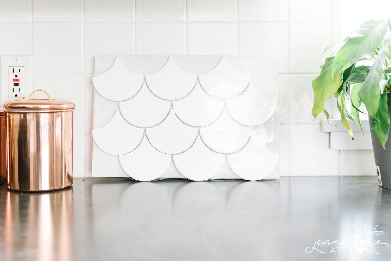 The original backsplash (square, white tiles) compared with the new backsplash tiles (white shell-shaped tiles)