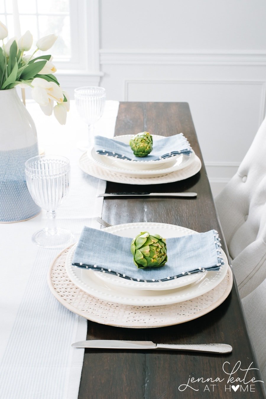 close-up of spring place settings with blue linen napkins and artichokes