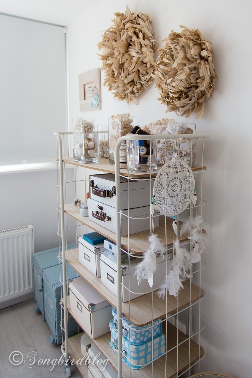 Use a rolling cart and decorative vases to store small items when organizing your craft room