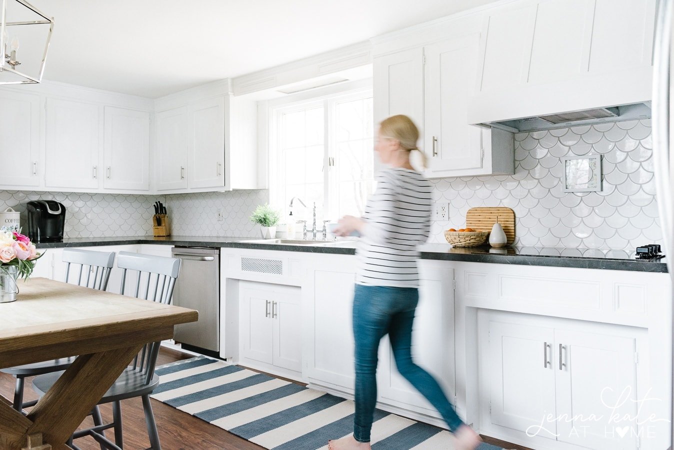 woman walking across striped kitchen runner