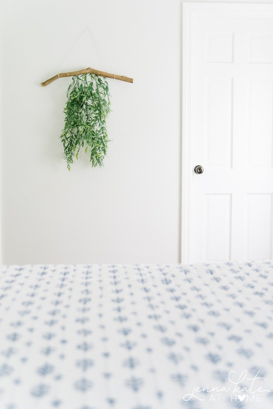 Branch hanging on wall, with green foliage cascading down