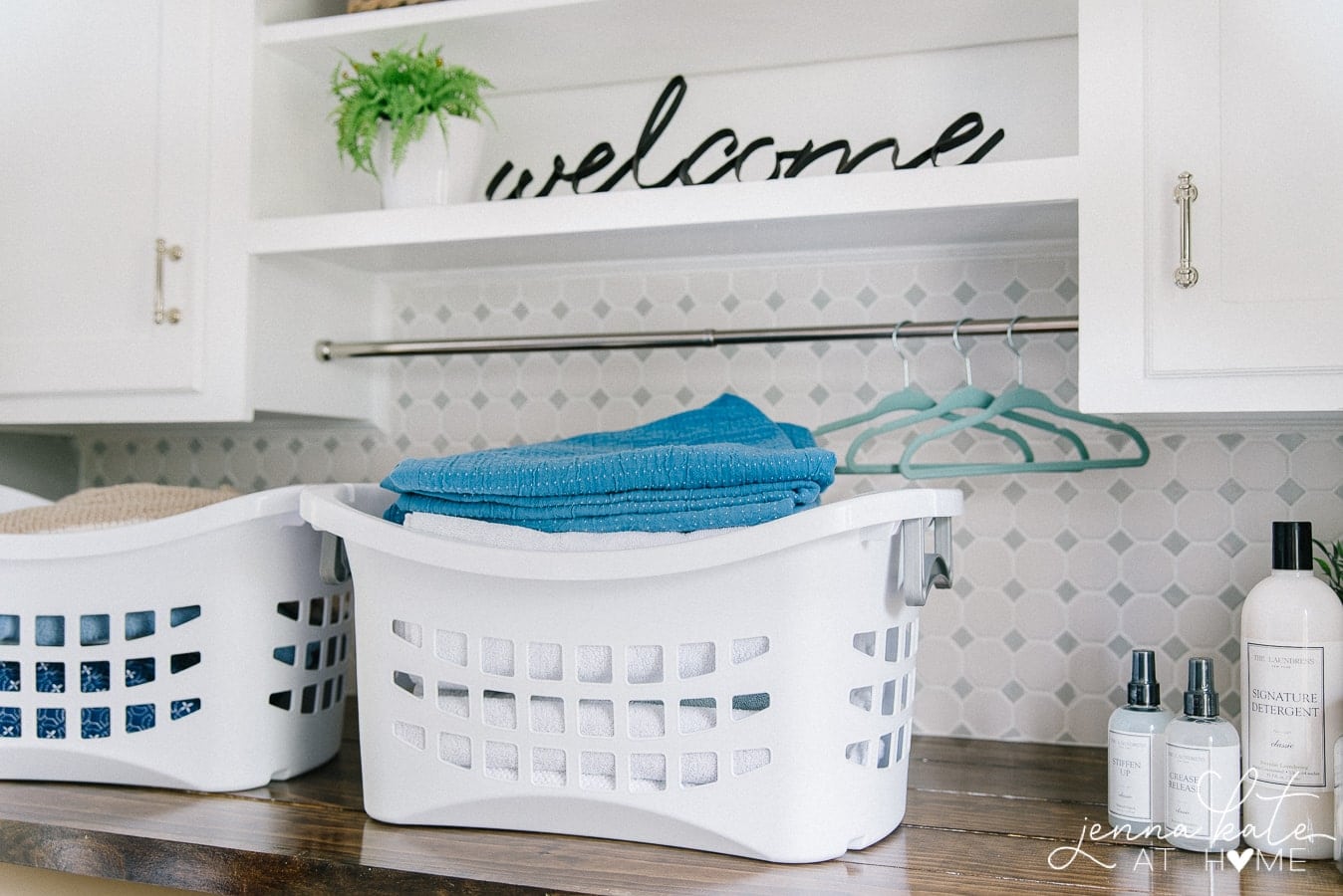 White laundry basket filled with clean towels, sitting on a new wooden shelf in the laundry room