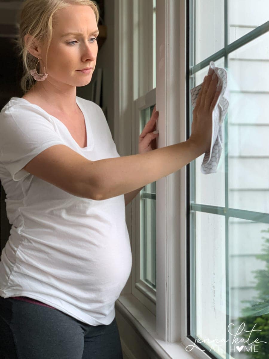 Jenna wiping a large window with a microfiber cleaning cloth