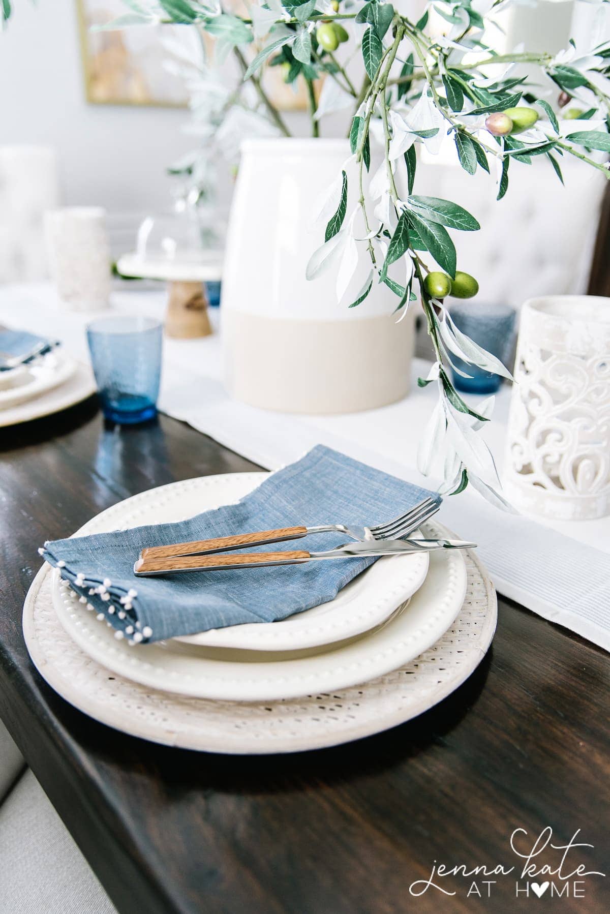 The blue linen napkins and coastal blue glassware give this coastal inspired tablescape pops of color