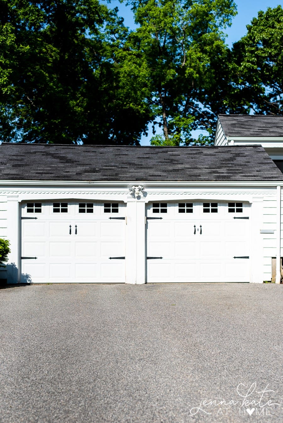 Dual garage doors, side by side, white with DIY window cutouts and other embellishments