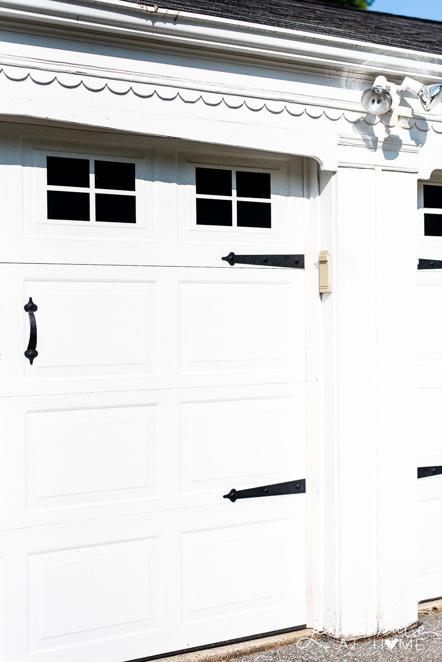 The upgraded garage doors with black vinyl decals for windows and plastic hardware attached with magnets