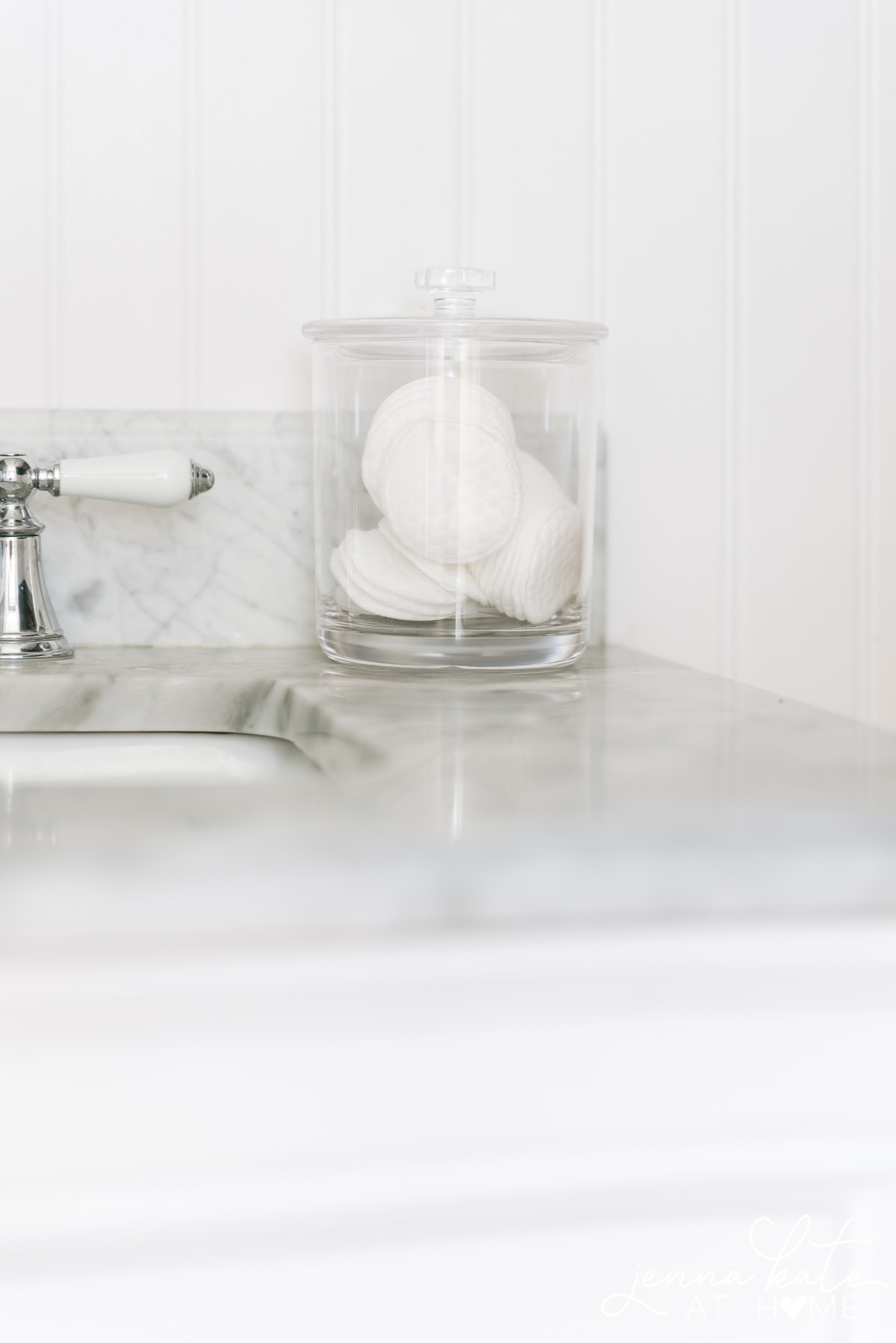 acrylic organizer filled with cotton rounds on top of bathroom counter