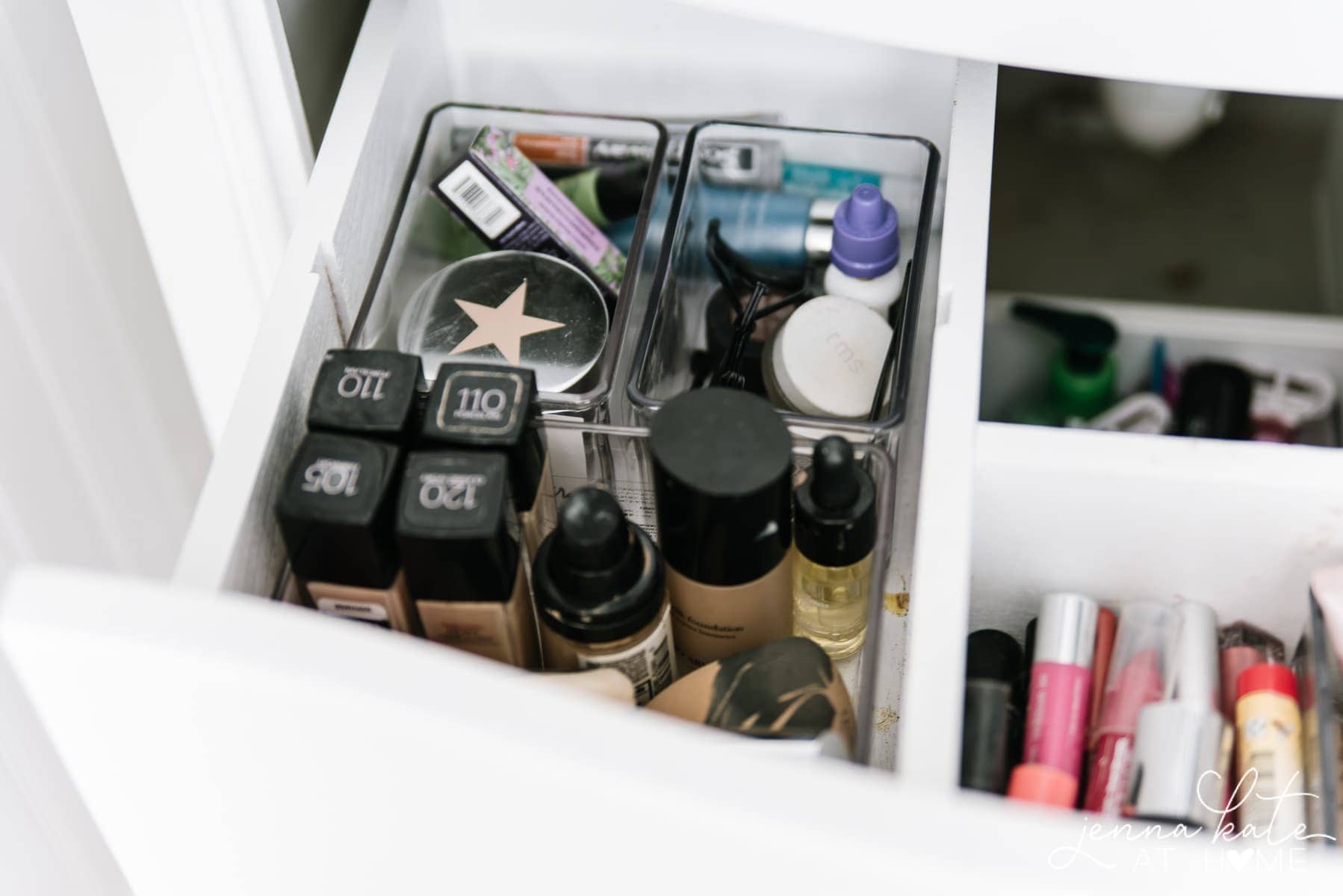 a collection of various makeup items in a bathroom drawer