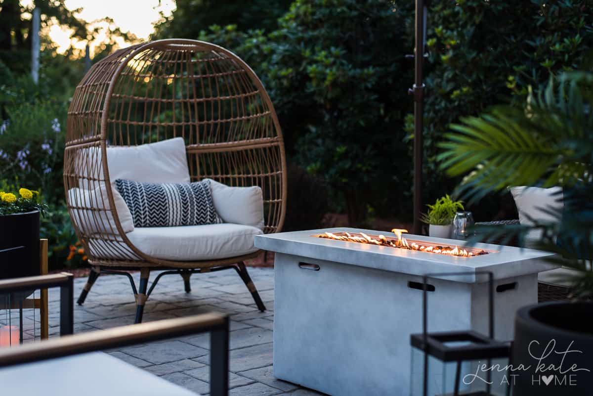 patio with an eggchair and a rectangular concrete firepit table.