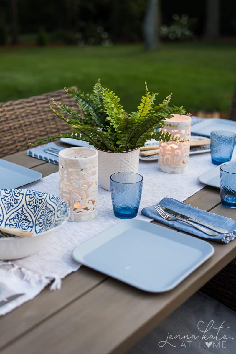 These tropical candle lanterns and ferns are the perfect tablescape decor for a coastal inspired backyard patio